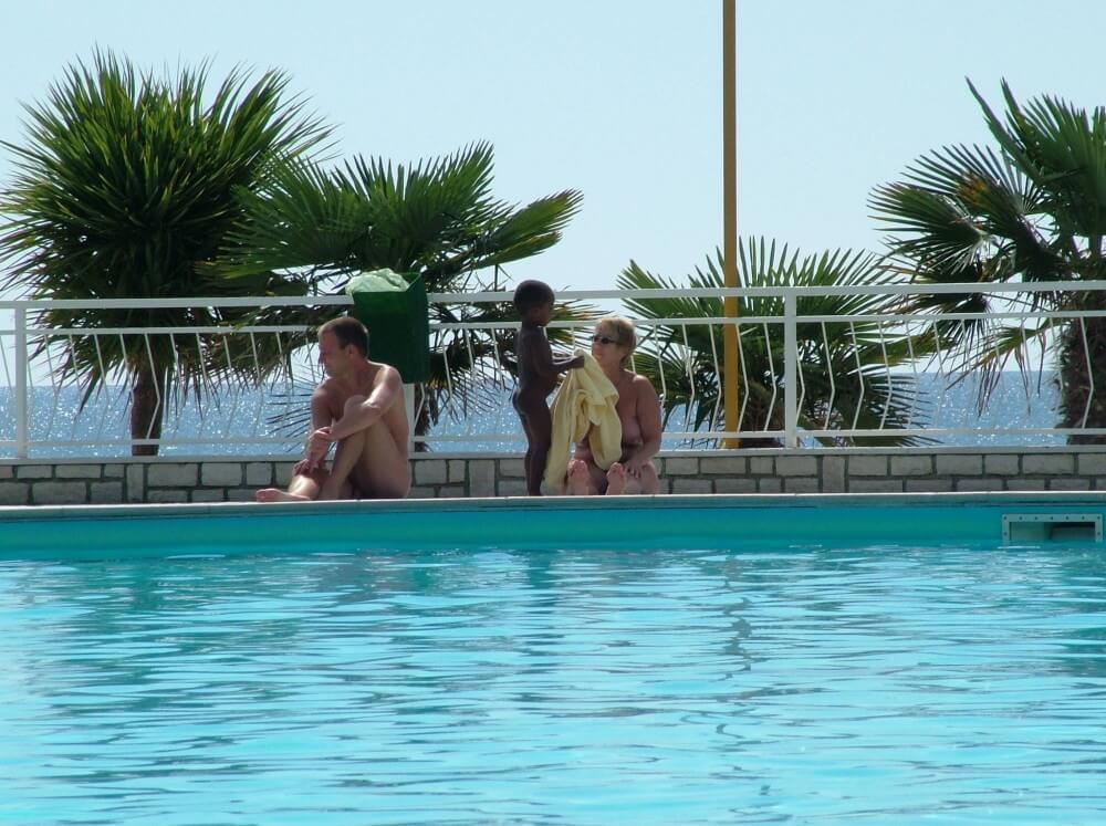 Photo of naturists in an outdoor pool - A life free of unnecessary worries is a hallmark of naturism